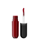 Lip tint da marca M·A·C: um frasco de vidro e um aplicador de batom preto com a marca impressa. O frasco contém um produto líquido.