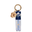 Embalagem de gloss labial da marca Bruna Tavares com textura suave e brilho, na cor Diamond, acompanhada de pingente dourado em formato de flor.