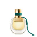 Frasco de perfume dourado com tampa e faixa verde, rótulo com a marca "NOMADE", embalagem de vidro com detalhes em relevo.