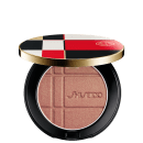 Pó Shiseido Color + Glow Enhancer  em embalagem redonda preta e dourada, com design xadrez em vermelho, branco e preto. O produto apresenta textura aveludada e logotipo da marca.