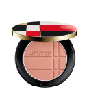 Pó Shiseido Color + Glow Enhancer  em embalagem redonda preta e dourada, com design xadrez em vermelho, branco e preto. O produto apresenta textura aveludada e logotipo da marca.