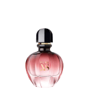 Perfume em frasco de vidro arredondado com tampa preta e detalhes dourados. O frasco é rosa translúcido, com o nome "PURE XS" impresso em letras douradas na parte frontal. A embalagem tem um formato elegante e sofisticado.