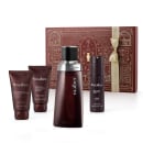 Kit Malbec. Embalagens marrons com detalhes decorativos em dourado. Inclui frasco de perfume, desodorante corporal, loção corporal, gel de banho e itens em tubos. Cores marrom escuro e detalhes em dourado, com design inspirado em padrões ornamentais.