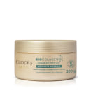 Embalagem plástica tipo pote, arredondada e na cor bege claro. Tampa de rosquear na parte superior do pote. Rótulo em verde, informação adicional de Pró-Saúde da Pele Madura e redução da flacidez.