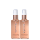 Dois frascos de óleo capilar brilhante da marca Brae. Os frascos têm um design cilíndrico transparente com um líquido de tom dourado.