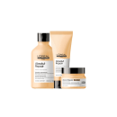 A imagem mostra um kit com três produtos da linha Absolut Repair da L'Oréal Professionnel. Um frasco de shampoo de 300ml, uma embalagem tubular de condicionador e um pote redondo. Todos com cor bege e tampa preta.