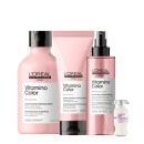 A imagem mostra a linha Vitamino Color da L’Oréal Professionnel, para cabelos coloridos, inclui shampoo (300ml), condicionador (200ml) e leave-in (190ml) em embalagens rosa e tampa preta. Completa o conjunto uma ampola embalagem branca e tampa prata.
