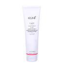 O produto apresentado é um creme leave-in da linha Confident Curl da marca Keune. A embalagem é um tubo branco com o logotipo da marca e o nome do produto "Confident Curl Leave-in Coily Creme".
