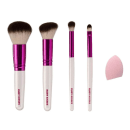 A imagem mostra quatro pincéis de maquiagem com cabo branco, detalhe rosa cromado e cerdas brancas com pontas escuras, além de uma esponja de maquiagem rosa.