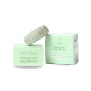 Shampoo sólido Equilíbrio da marca Tropicália Cosméticos Naturais, em embalagem de caixa e barra de sabonete verde-clara, com rótulos e informações sobre os ingredientes naturais.