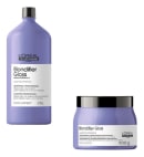 A imagem mostra dois produtos da linha Blondifier Gloss da L'Oréal Professionnel. Um é um shampoo profissional em uma embalagem plástica cilíndrica lilás de 1,5 litros. O outro é uma máscara em um pote plástico lilás de 500 gramas.