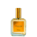 Perfume em frasco de vidro transparente com líquido âmbar. Embalagem com tampa dourada. Rótulo retangular na parte frontal com o nome "Hazor" escrito em letras pretas sobre fundo âmbar. Logotipo da marca Thera Cosméticos visível abaixo do nome do produto.