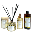 Linha de produtos de aromatização ambiental da marca Perfuma & Decora. Inclui difusores de aromas com varetas, um frasco de vidro âmbar para refil, um frasco de vidro transparente com tampa dourada para difusor, uma vela perfumada em vidro transparente.