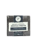 Sabonete artesanal de argila preta da marca Cheiro Brasil. A embalagem possui um rótulo branco com informações sobre o produto, incluindo seu nome, descrição de suas propriedades secativas e nutritivas, e que é um produto vegano sem testes em animais.