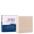 A imagem mostra um sabonete em barra antimicrobiano ozonizado da marca La Venia Cuidados Ozonizados. O produto vem em uma embalagem retangular de papelão nas cores branca e azul marinho. Enquanto a barra do sabonete tem cor bege.