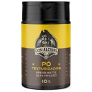 Frasco preto e amarelo de 10g contendo pó texturizador da marca Don Alcides, com efeito matte e alta fixação, conforme indicado no rótulo do produto.