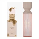 Dois frascos de perfume da marca Lattafa, um em tom dourado com detalhes em relevo e outro em tom rosado com desenho ondulado. Ambos os frascos apresentam rótulos com o nome "Eclaire" em árabe e em inglês.