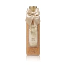 Frasco dourado com laço de cetim bege contendo sais de banho com aroma de maçã e canela, da marca Empório Essenza, da Serra Gaúcha.