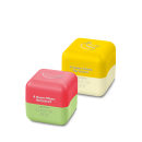 Dois cubos coloridos de produtos de beleza da marca Cuide-se Bem, com textos em português indicando "Quem disse, Berenice?". O cubo amarelo possui um símbolo de banana, enquanto o cubo verde e rosa possui um símbolo de melancia.