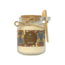 Frasco de vidro com sal de banho da marca Kailash Serenata, com rótulo colorido com padrões florais e texto em inglês. Possui tampa de cortiça e uma colher de madeira.