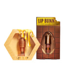 Lip Bunny, um gloss labial de chocolate com efeito vinílico, e Lip Honey, um produto de hidratação intensa, ambos da marca Fran by Franciny Ehlke, apresentados em embalagens de design moderno e cores vibrantes de amarelo e marrom.
