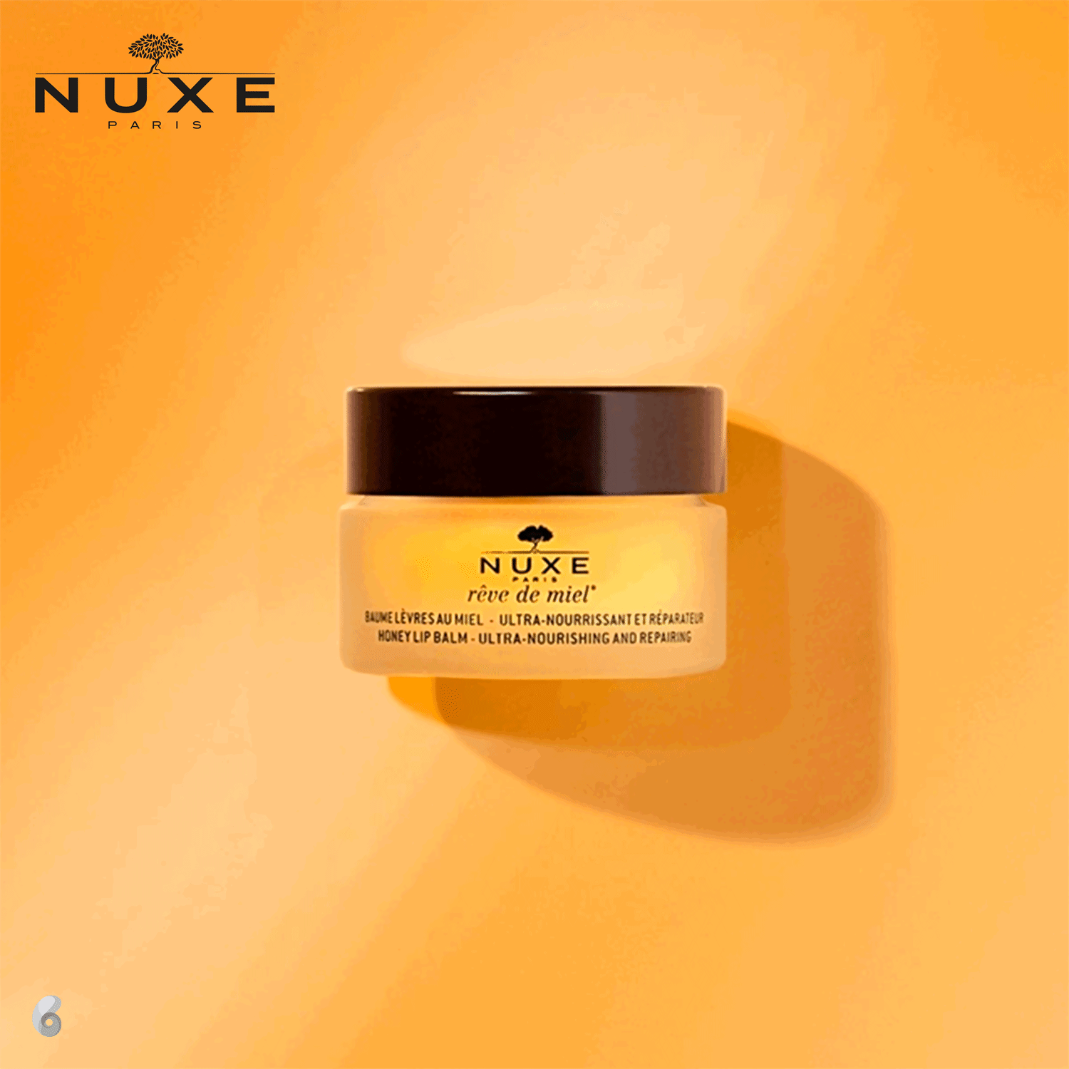 Rótulo amarelo com o nome do produto "Rêve de Miel" (Sonho de Mel) e descrição "Baume Lèvres au Miel - Ultra-Nourrissant et Réparateur" (Bálsamo Labial com Mel - Ultra Nutritivo e Reparador).