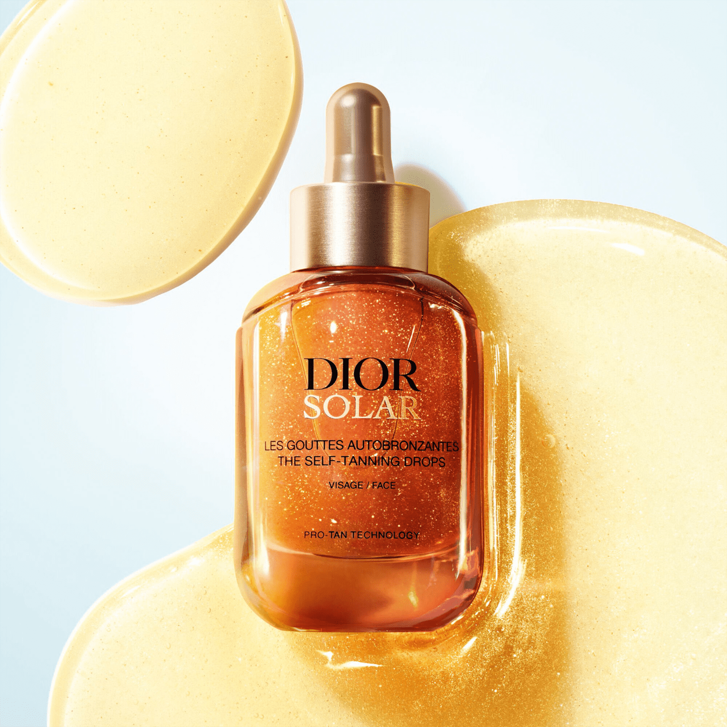 Frasco de vidro com conta-gotas dourado contendo um líquido alaranjado brilhante, rotulado como "DIOR SOLAR - The Self-Tanning Drops" em fundo branco e dourado.