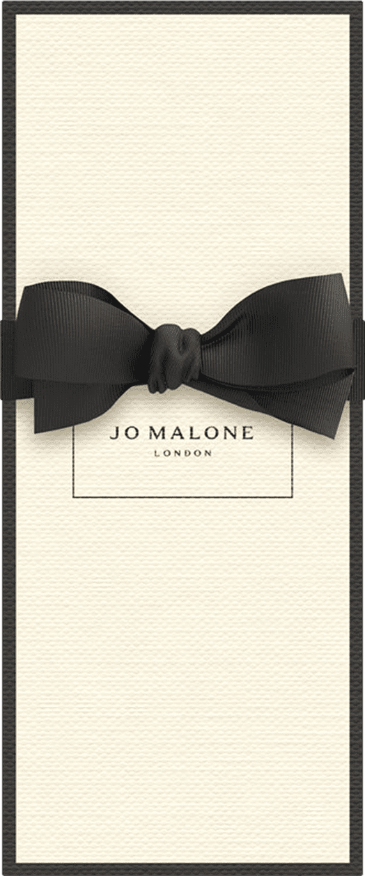 Caixa retangular de papelão branco com bordas pretas, contendo o logotipo "Jo Malone London" impresso. Um laço preto de cetim adorna a parte frontal da caixa.