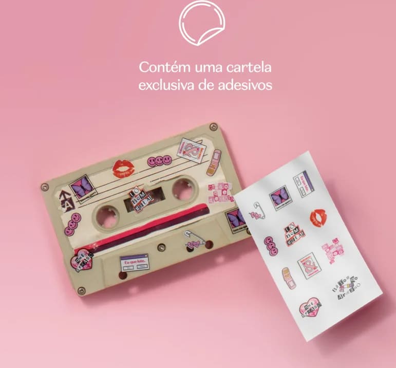 Cartela de adesivos decorativos em tons de rosa e roxo, com ilustrações diversas, como lábios, corações, borboletas e outros elementos gráficos, apresentada ao lado de uma fita K7 cinza com os adesivos colados nela contra fundo rosa claro.