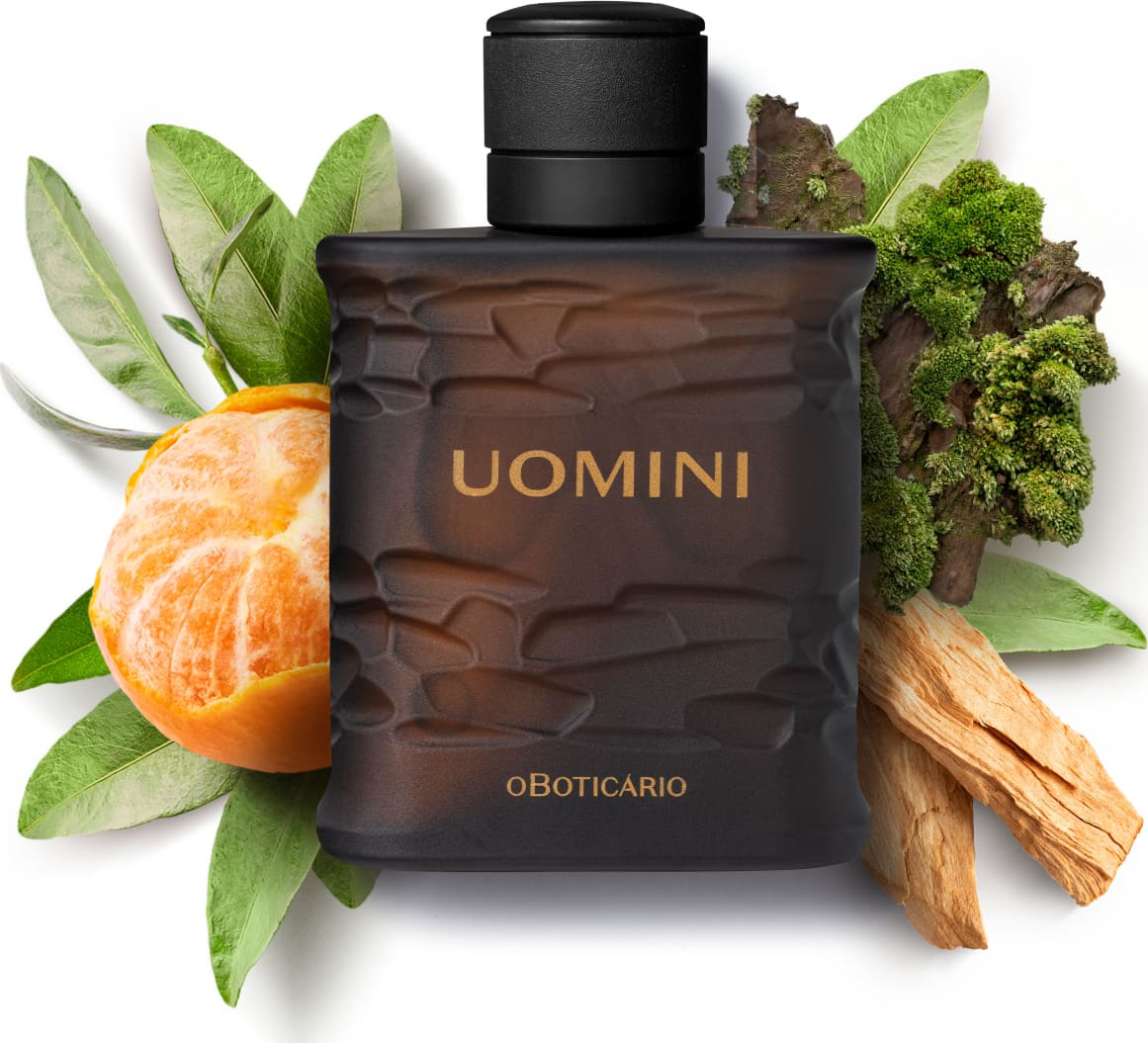 Frasco retangular marrom com texturas onduladas, tampa preta e letras bege, contendo desodorante colônia da marca Uomini, rodeado por gomos de bergamota, folhas verdes, musgos e pedaços de madeira.