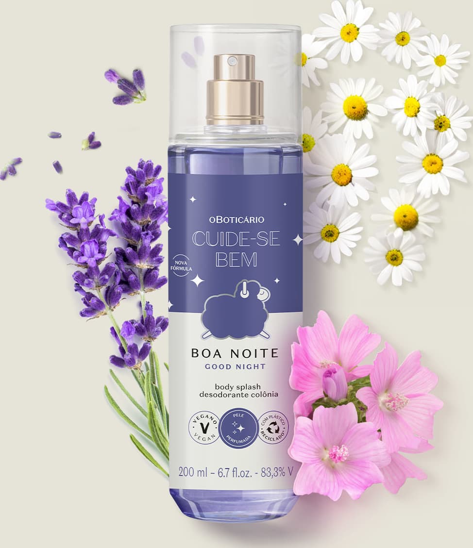 Frasco com líquido azul claro, pulverizador prateado, tampa transparente e rótulo azul escuro e branco com ovelhinha ilustrada de body splash da marca Cuide-se Bem Boa Noite em meio a flores e folhagens roxas e brancas sobre superfície clara.