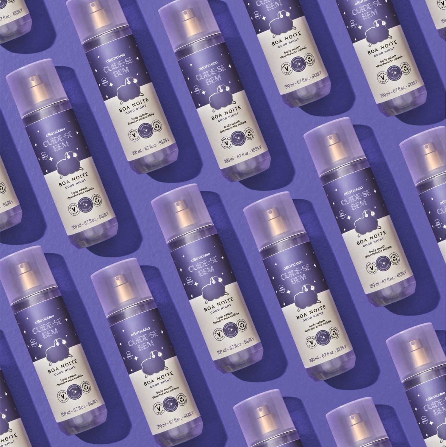 Diversos frascos com rótulos azuis e brancos contendo body splash da marca Cuide-se Bem Boa Noite dispostos lado a lado em um fundo azul escuro.