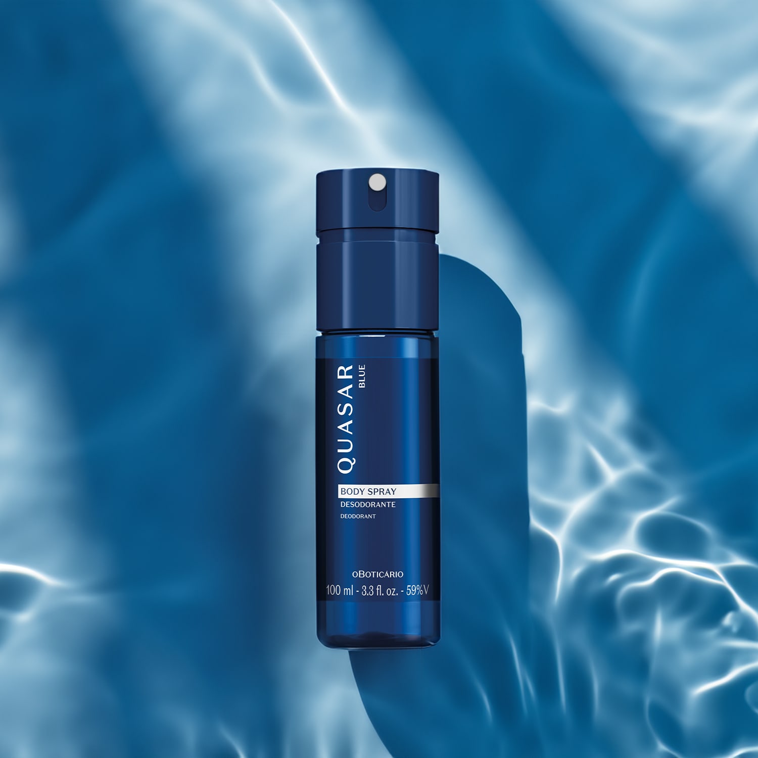 Frasco azul marinho com letras amarelas e detalhe branco contendo  body spray desodorante da marca Quasar Blue em azul, sobre superfície com reflexos e sombras em tons de azul, em ambiente com iluminação e nuvens.