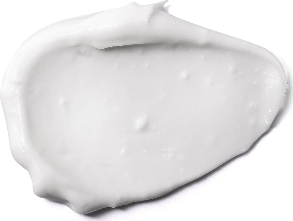 Textura branca e lisa do creme reparador hidratante da marca Boti Baby Cicababy. com aparência opaca e densa, espalhado em superfície branca.