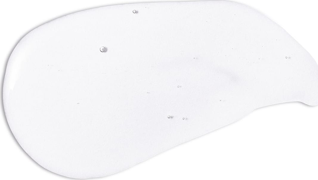 Textura branca e gelatinosa de shampoo suave da marca Boti Baby com aparência fluída e brilhante, espalhada em superfície branca.