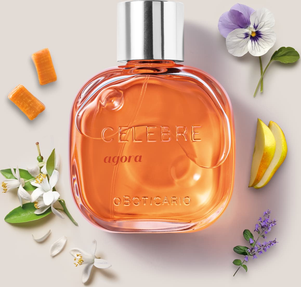 Frasco de vidro transparente com líquido laranja, tampa prateada e letras pretas e em relevo contendo de desodorante colônia Celebre Agora Feminino, rodeado por caramelos, violeta, flor de laranjeira e peras frescas.