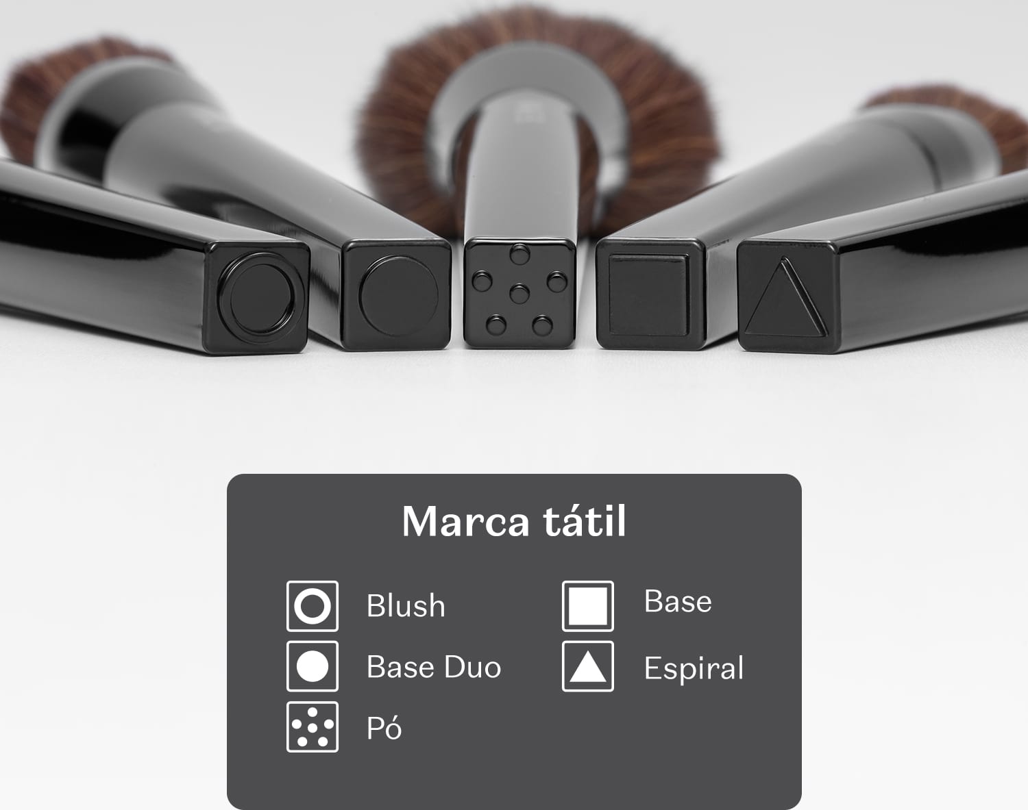 A imagem mostra que os pincéis da linha possuem marca tátil na base, indicando sua finalidade. Círculo vasado blush, circulo cheio base duo, pontinhos pó, quadrado base e triângulo espiral.