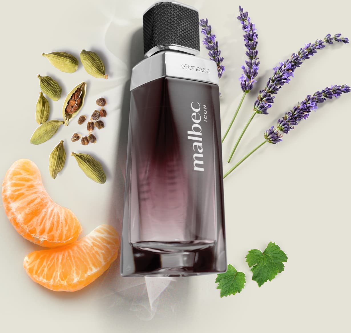 Vidro com degradê de preto e branco, detalhe prateado próximo à tampa preta e rótulo com letras cinza de desodorante colônia Malbec Icon em primeiro plano, rodeado por especiarias, flores de lavanda e fatias de laranja sobre superfície clara.