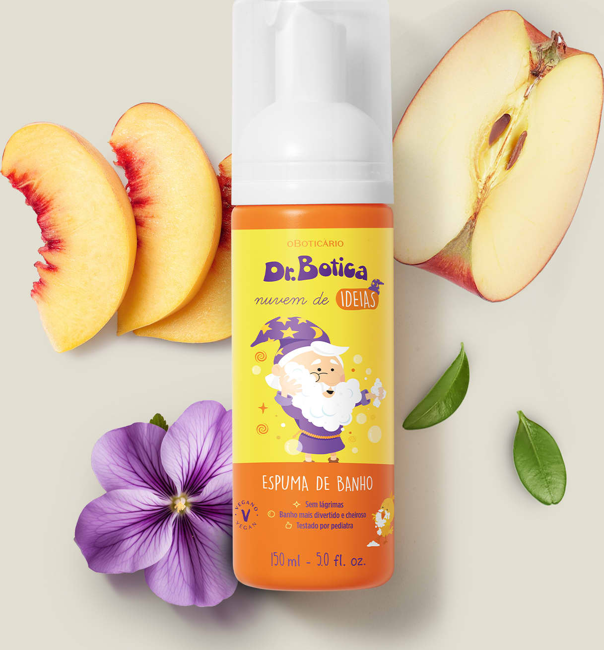 Espuma de banho corporal Nuvem de Ideias Dr. Botica em frasco com tampa branca e rótulo amarelo e laranja com ilustração do personagem da marca sobre superfície clara, com fatias de pêssego, maçã e flor roxa ao redor, em cenário minimalista e natural.