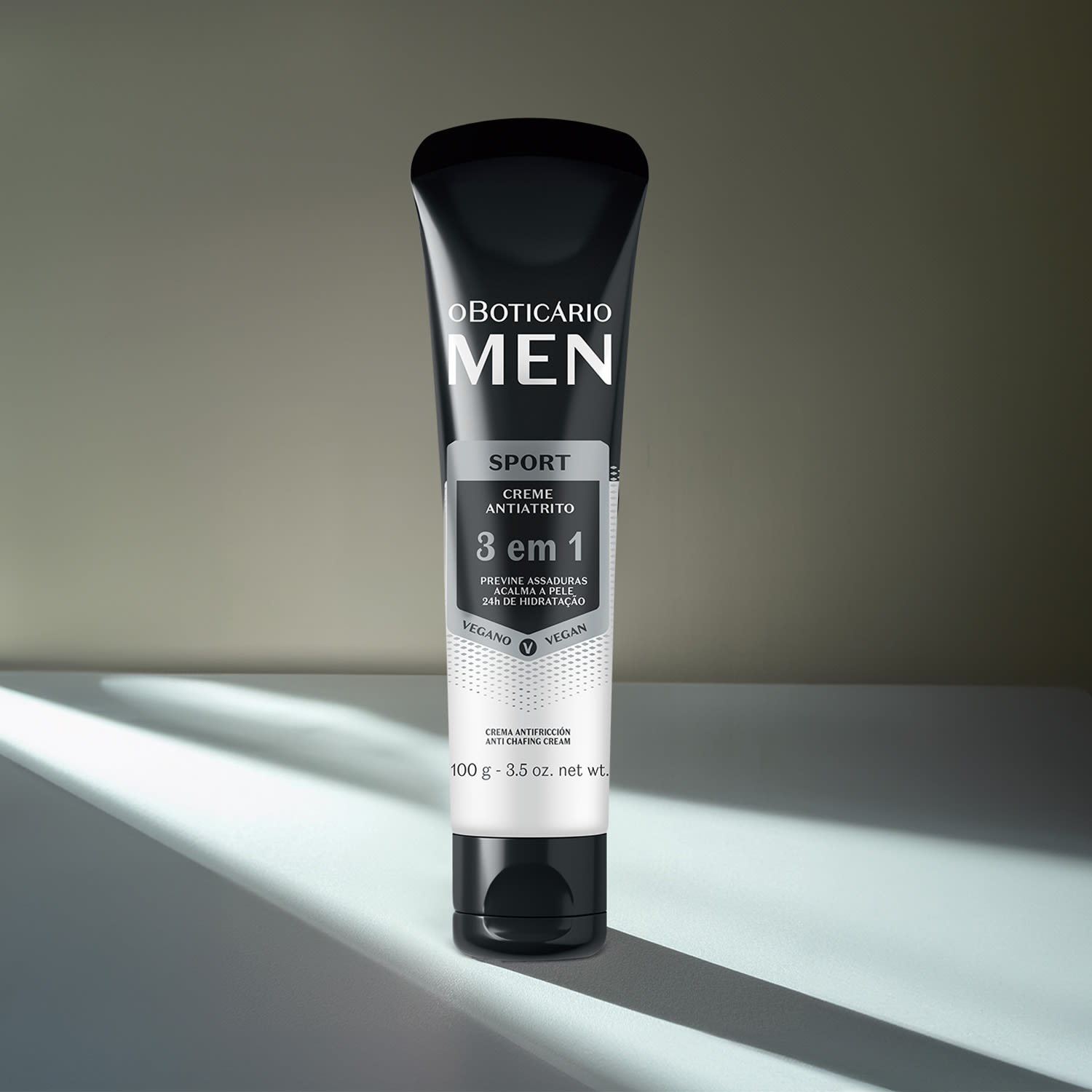 Bisnaga preta e branca com detalhes cinza de creme antiatrito 3 em 1 da marca Men Sport. em cenário escuro com alguma iluminação natural em cima da embalagem.