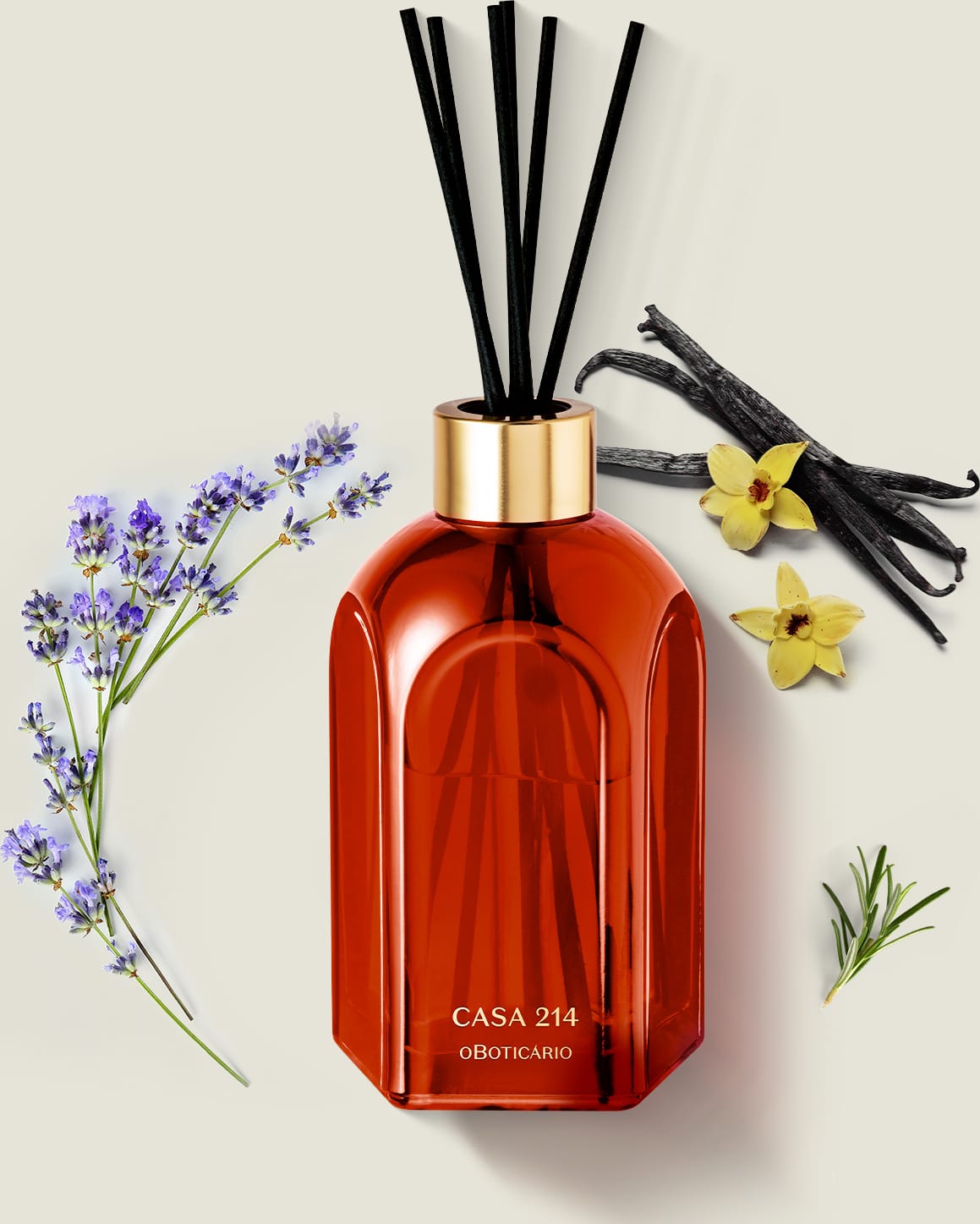 Difusor de ambientes em vidro laranja com varetas e letras douradas da marca Casa 214 Vanilla Sublime em ambiente com flores de lavanda, baunilha e ramos de madeira, sobre superfície clara.