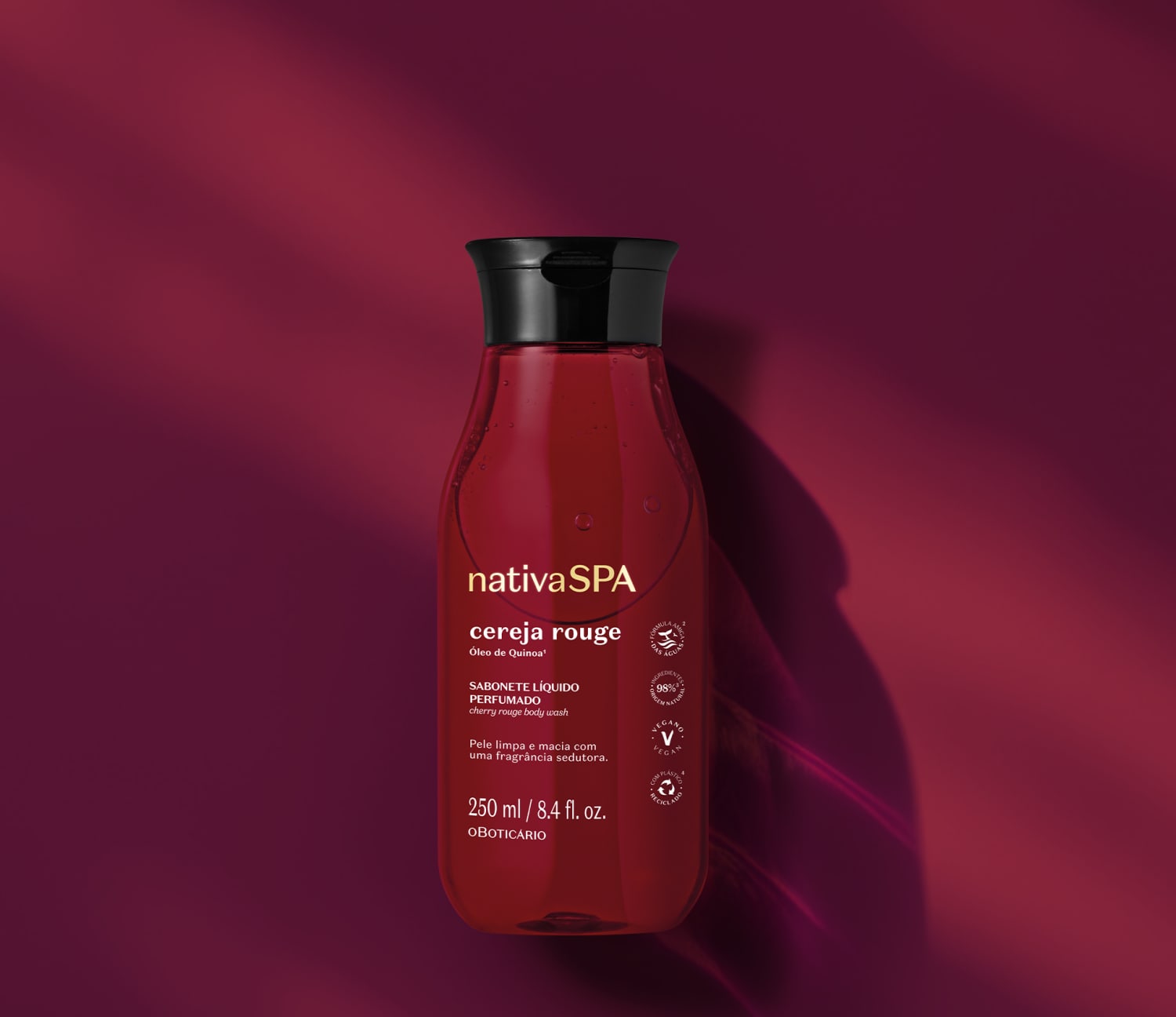 Frasco transparente com liquido vermelho escuro, tampa preta e rótulo em letras brancas e douradas contendo 250ml de sabonete líquido da arca Nativa SPA Cereja Rouge em fundo vermelho escuro.
