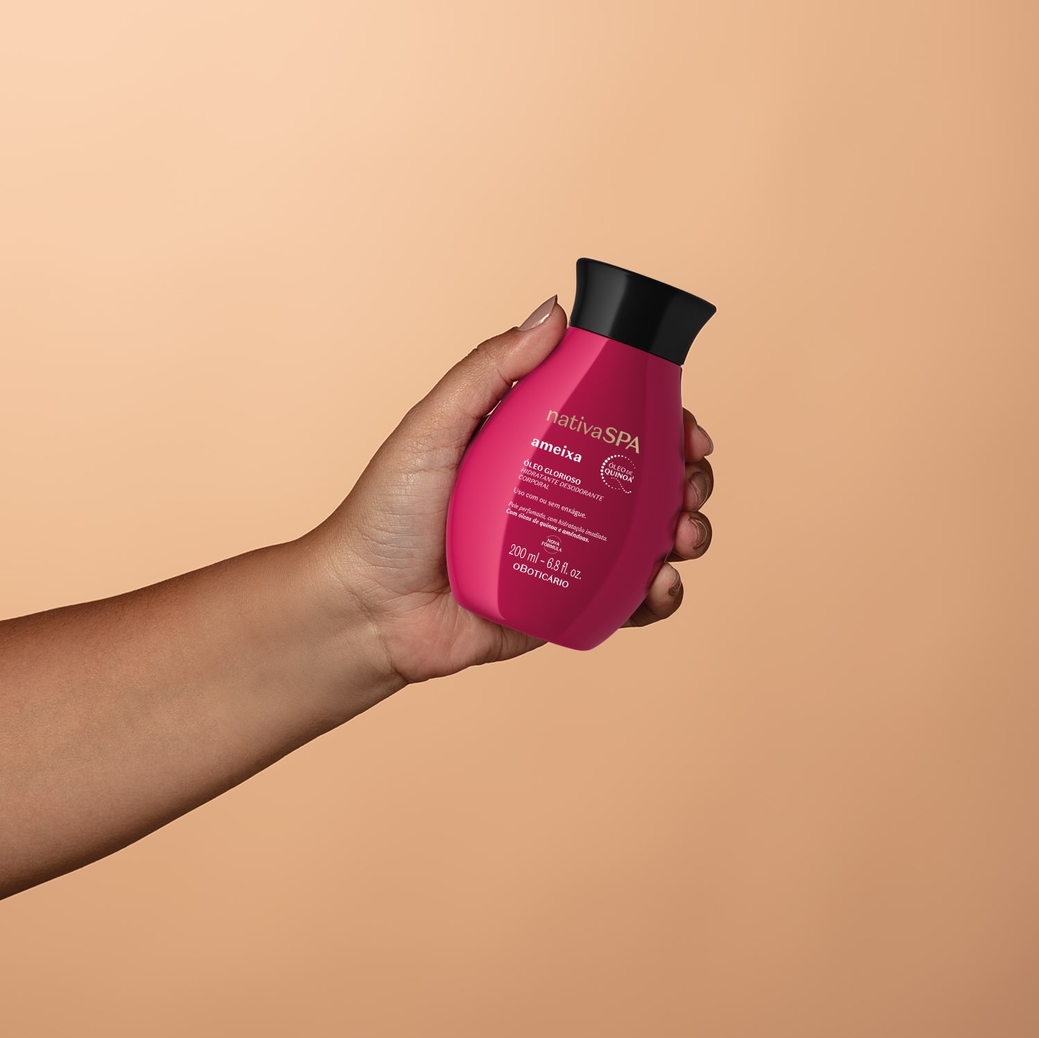 Imagem de um frasco de óleo glorioso corporal da marca Nativa SPA Ameixa, em tom vermelho, sendo segurado por uma mão em fundo em tons de roxo.
