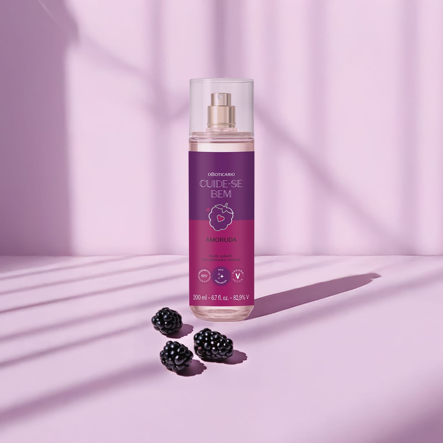 Ambiente de beleza com frasco de body splash da marca Cuide-se Bem Amoruda em tons de roxo, acompanhado de amoras frescas, em um cenário minimalista e elegante.