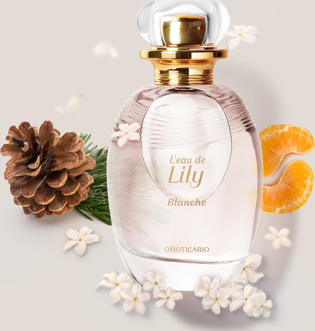 Frasco de desodorante colônia da marca L'eau de Lily Blanche em ambiente com flores brancas, pinhas e fatias de laranja, sobre superfície clara.