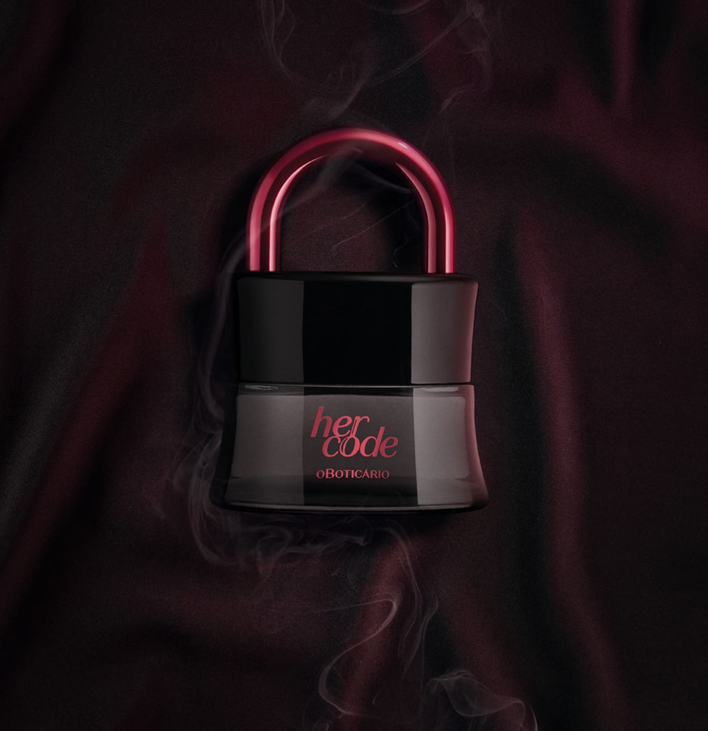 Imagem de um vidro preto em formato de cadeado com arco rosa metalizado de Eau de Parfum Her Code Clímax, suspensa em ambiente escuro com fumaça, sobre superfície escura.