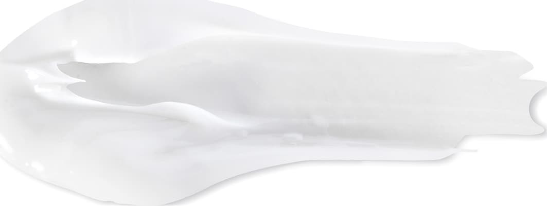 Objeto branco com textura suave e brilhante, com aparência cremosa e delicada. Possui formato irregular e assimétrico, sugerindo tratar-se de um item de  corpo e banho