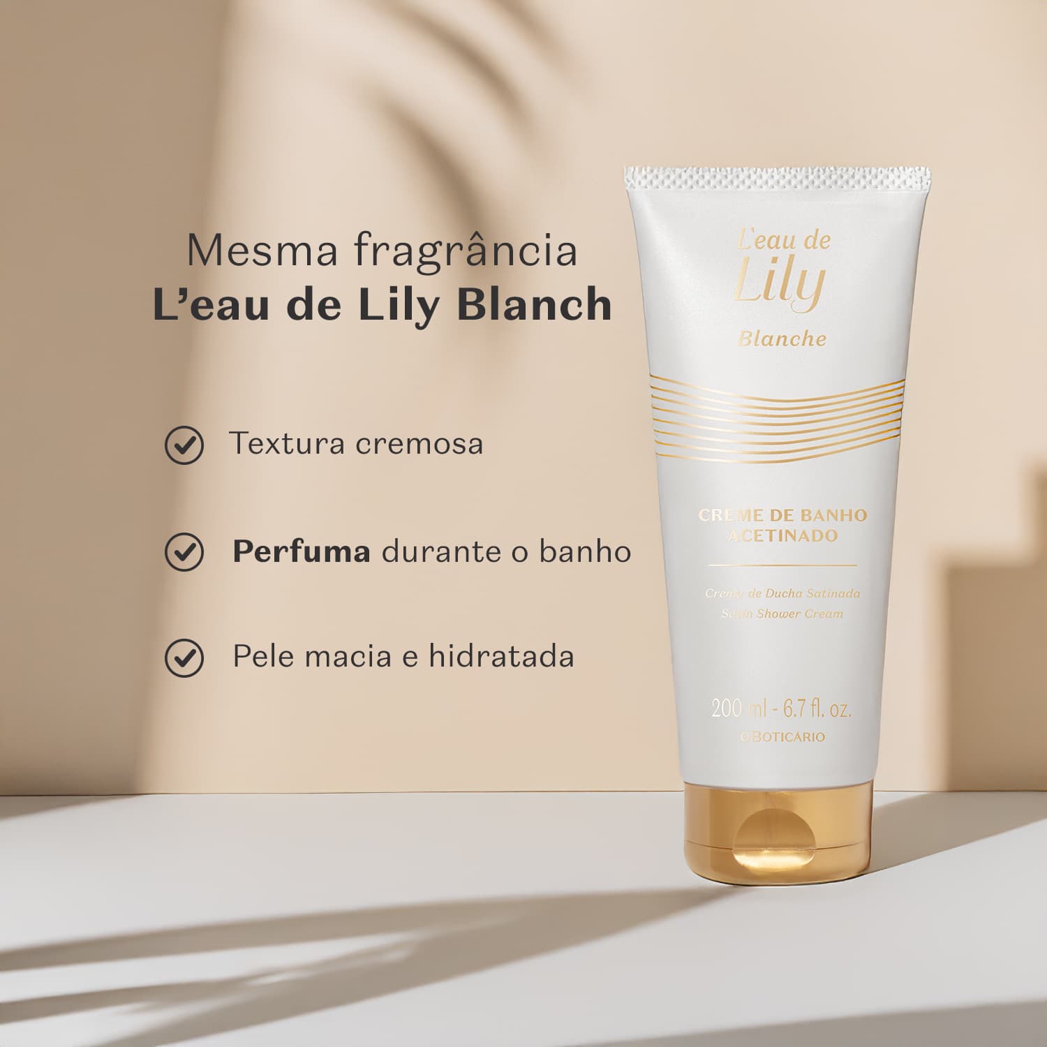 Imagem de um frasco branco com tampa e rótulo dourados da linha L'eau de Lily Blanche, contendo 200ml de creme de banho acetinado. Ele está em fundo neutro com sombreado e texto informando os benefícios do produto.
