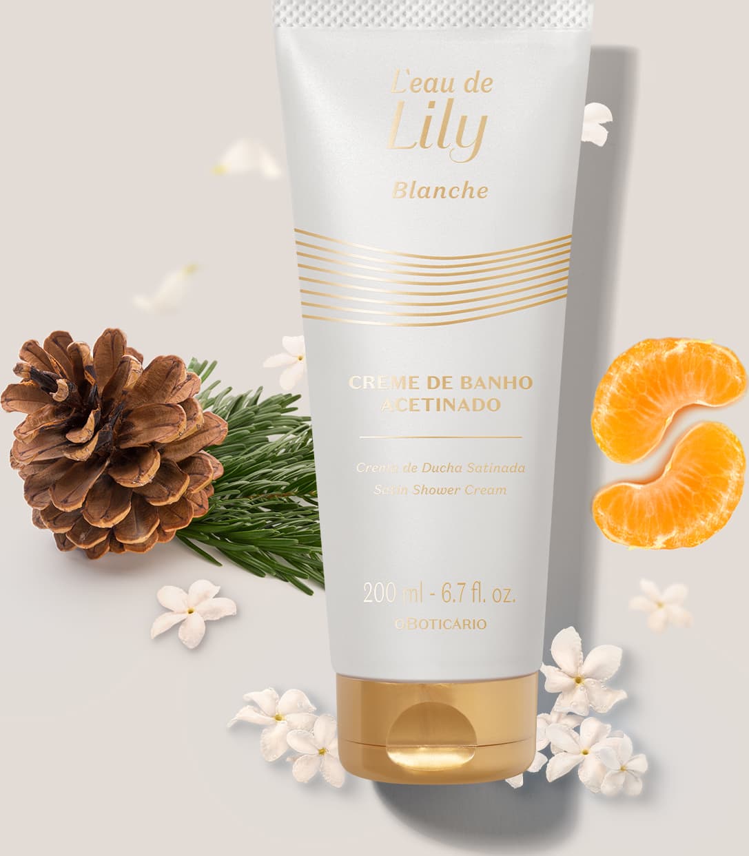 Imagem de um tubo branco e dourado de creme de banho acetinado corporal L’eau de Lily Blanche, com flores brancas, fatias de laranja e pinhas em fundo bege claro.