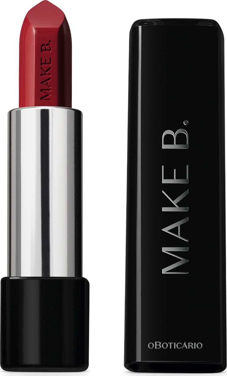 Batom em tom de vermelho da marca Make B. aberto. De um lado, a tampa preta com texto em branco, com formato retangular e ponta arredondada. Do outro, a base preta, o corpo prateado e a bala de batom aparente com a marca gravada em baixo relevo.